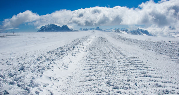 道路上的雪美容机，或雪车，在冰川表面的高山。图片下载