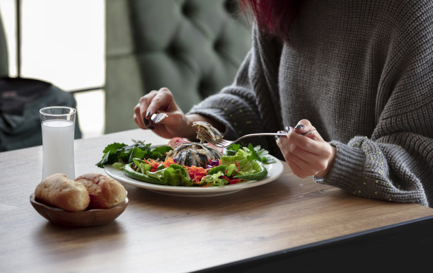 女孩吃凤尾鱼饭-哈姆西肉饭-肉饭和喝土耳其拉基图片下载
