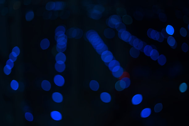 蓝圈散景与夜晚灯光和黑暗的背景类似于夜晚的时间，作为背景在冬季的夜晚使用镜头模糊的照片图片下载