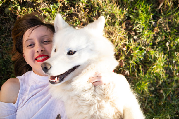 一个漂亮的女孩抱着她的狗狗库存照片图片下载