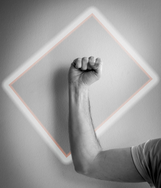 在一个彩色的矩形内，一个紧握的拳头的手臂的特写。图片下载