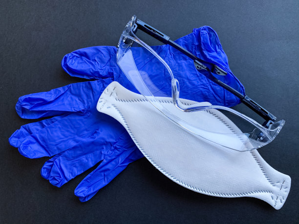 白色医用口罩防护PPE2。保护性透明眼镜。蓝色腈手套。图片下载