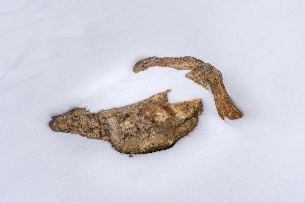 被雪覆盖的石头。图片下载