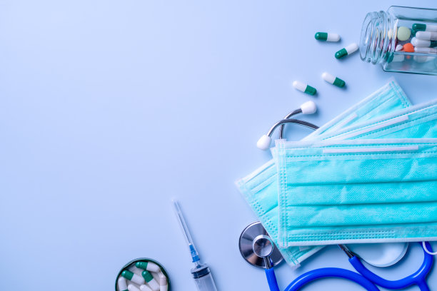 口罩与药片，听诊器，注射器医疗供应对象隔离在蓝色背景，头顶拍摄，病毒保护概念。图片下载