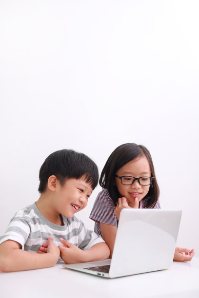 亚洲小男孩和女孩在白色背景下使用笔记本电脑图片下载