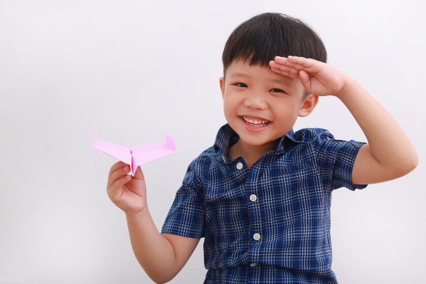 可爱的亚洲男孩玩纸飞机图片下载