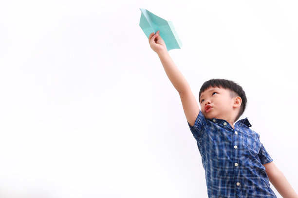 可爱的亚洲男孩玩纸飞机图片下载