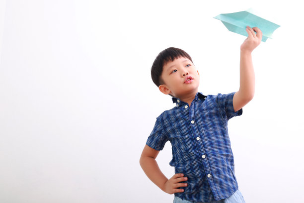 可爱的亚洲男孩玩纸飞机图片下载