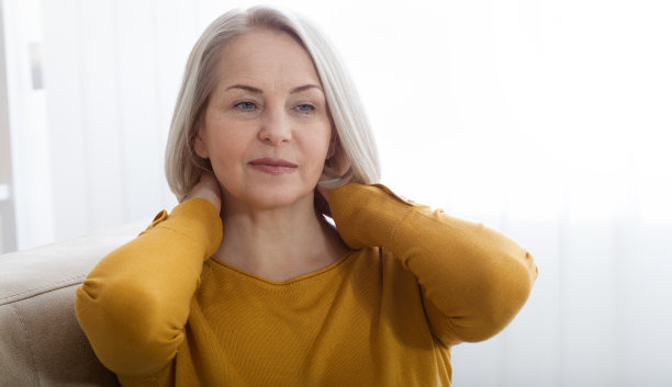 一个颈部疼痛的女人，在家被医生射中。概念照片，标明疼痛的位置。图片下载