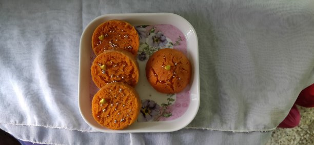 橙色蛋糕切片在盘子里。白色背景上的蛋糕片。Eggless蛋糕的照片。蛋糕切片心装饰。图片下载