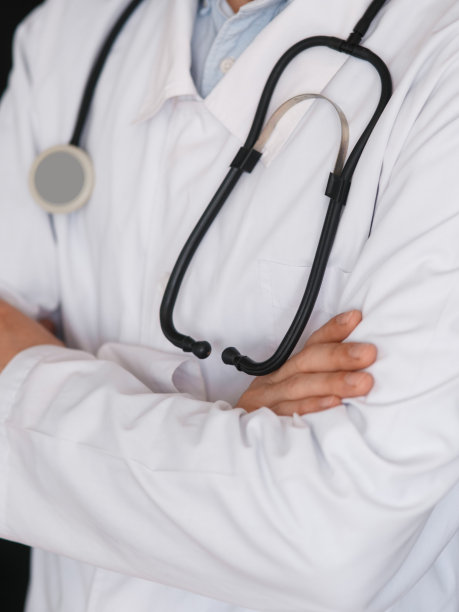 黑色背景下的男医生手中拿着听诊器，特写图片下载