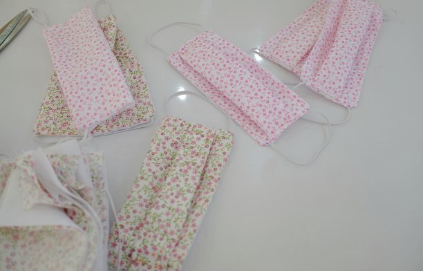 白色的桌子上散布着许多小的花卉图案妇女的口鼻面罩预防泻药疾病图片下载