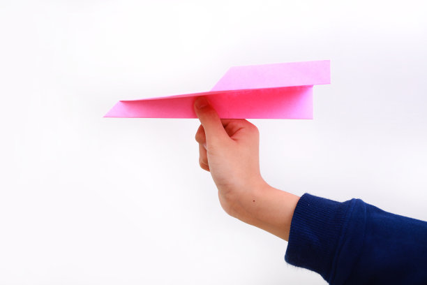 手持纸飞机在白色的背景图片下载