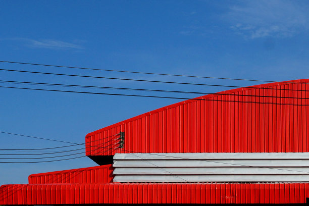 蓝色天空背景下的红色工厂屋顶。图片下载