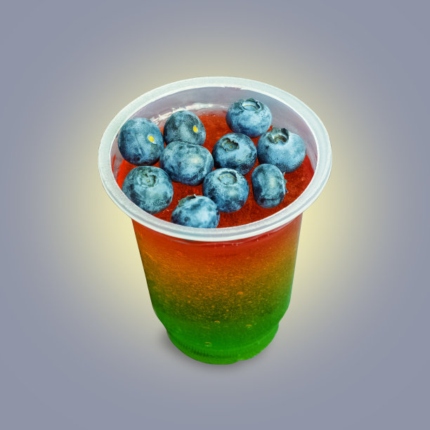 塑料透明杯与多色果冻和蓝莓在它的灰色背光背景图片下载