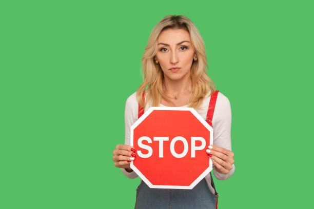 禁止进入，禁止进入!肖像严肃专横的成年妇女持有八角形红色停止交通标志图片下载