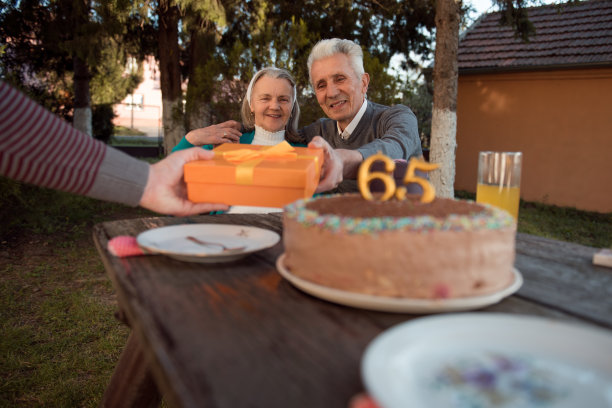 快乐的老年夫妇在生日聚会上收到礼物图片下载