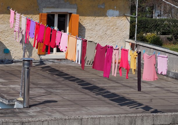 五颜六色的衣服挂在晾衣绳上晾在阳台上。图片下载