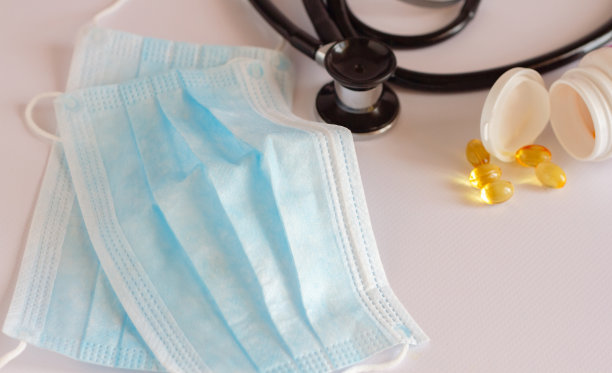 弯曲医用口罩图像，医用制剂，听诊器听肺和确定肺炎。冠状病毒——2019年和2020年全球大流行。图片下载