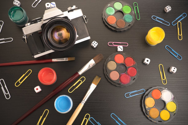 老式单反相机，彩色颜料和骰子在背板上。艺术/创意概念。图片下载