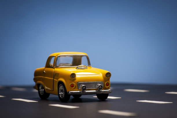 蓝色背景上的黄色玩具车。图片下载