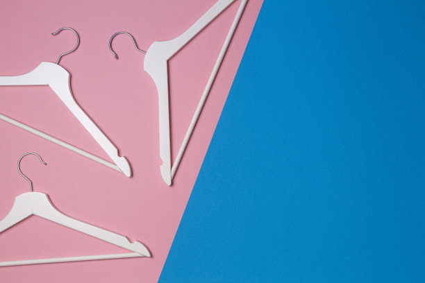 白色木制衣架，粉蓝色背景。俯视图，文本购物，销售，促销，社交媒体，新季节概念的拷贝空间图片下载