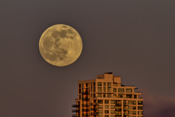 日落时分的公寓楼与满月图片下载
