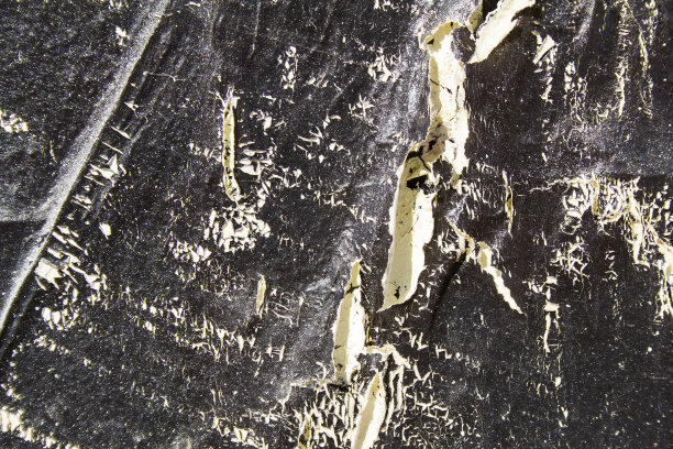 黑色的城市垃圾墙与旧裂痕和剥落的油漆纹理背景。图片下载