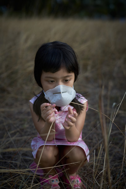 亚洲女孩的肖像在防护医疗面具玩在野外图片下载