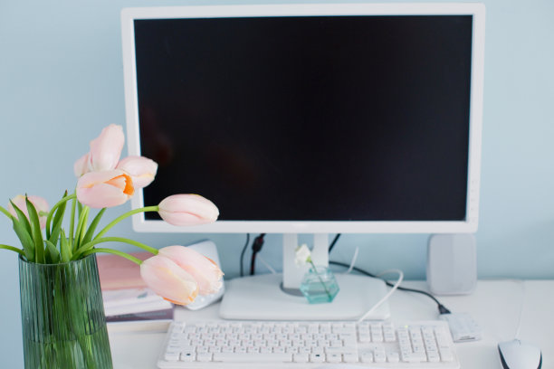 现代的工作场所，明亮的房间和蓝色的墙壁。桌上放着一束粉红色的郁金香。图片下载