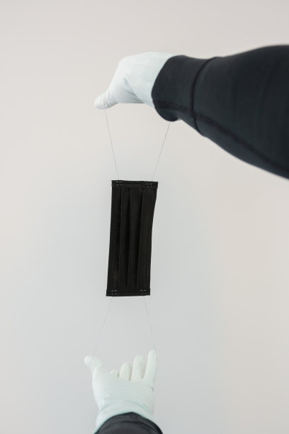 男子手持橡胶手套，黑色面罩图片下载