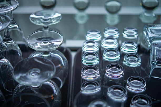 葡萄酒和伏特加酒杯放在餐厅酒吧架子上方的架子上。蓝色的灯光，蓝色的背景，夜生活图片下载