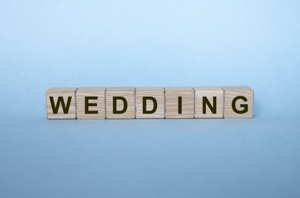 在浅蓝色的背景上，在木方块上的字婚礼。图片下载