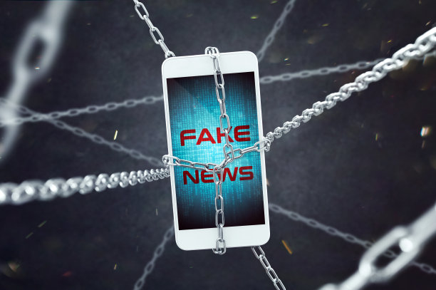 带有假新闻题词的智能手机被链条锁住。假新闻问题日益严重的概念。图片下载