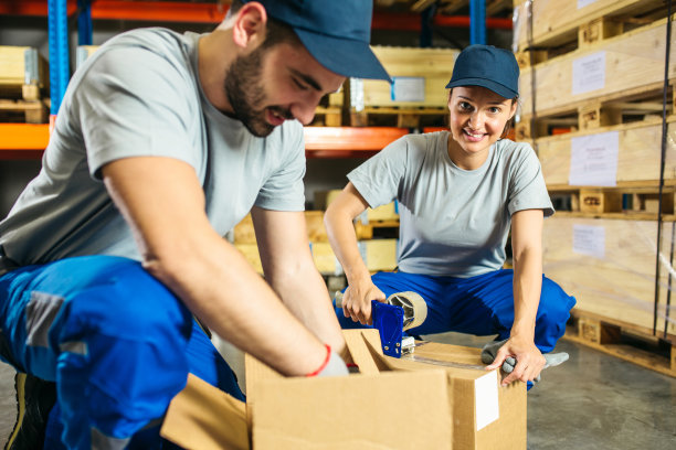 仓库包装箱的年轻体力劳动者图片下载
