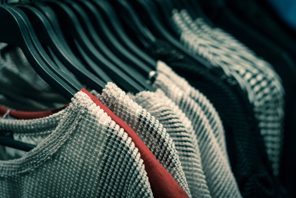 时尚的灰色和红色调女装挂在货架上，在美国德克萨斯州的高端商店图片下载