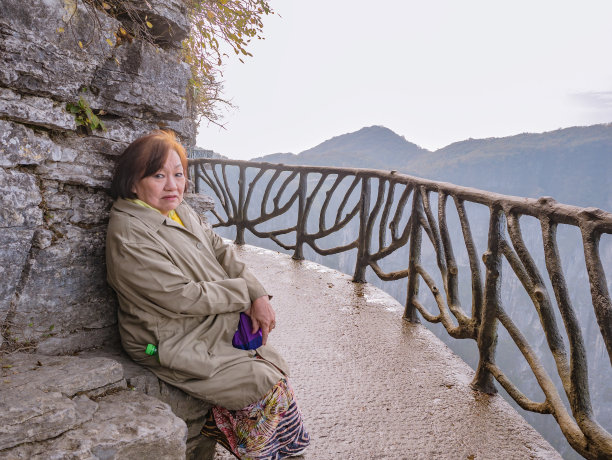 肖像照片美丽的亚洲妇女与美丽的风景天门山和晴朗的天空在中国张家界城市。图片下载