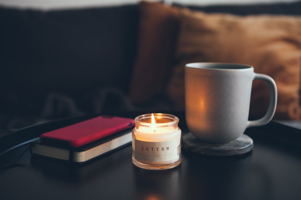 在家里喝着茶，桌上放着蜡烛，享受着温暖的冬夜。图片下载