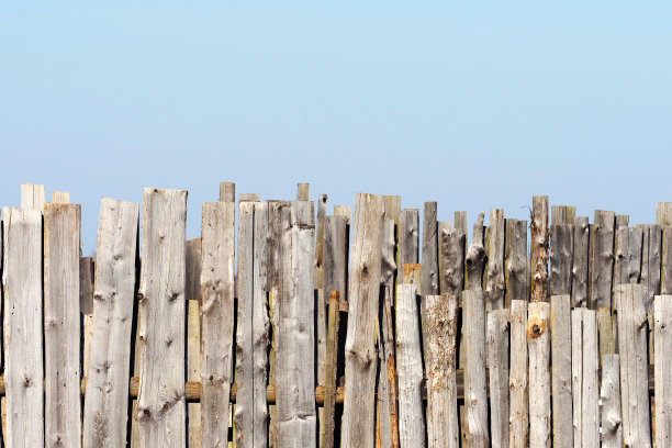 破旧粗糙的木栅栏映衬着蓝天图片下载