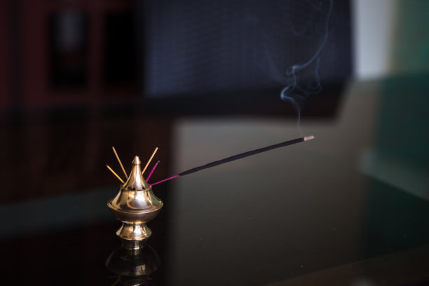 印度香在金色的架子上冒烟。图片下载