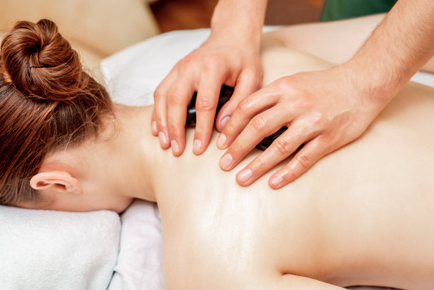 女人背部的石头按摩。图片下载