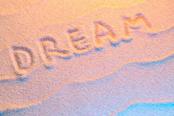 用波浪和霓虹灯在沙滩上刻下梦想的字母。最小的异国情调，度假和旅游的概念，平铺顶视图拷贝空间图片下载