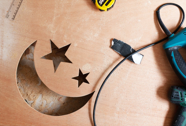 木工：从胶合板上切割月亮和星星，使用轮盘、尺子和电动曲线锯图片下载