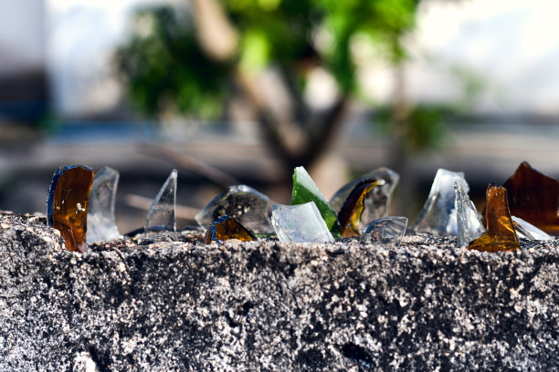 混凝土栅栏与保护小偷从碎玻璃的背景散景图片下载