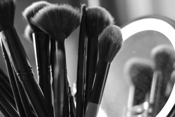 一组化妆刷的黑白照片反射在一个圆形的镜子里图片下载