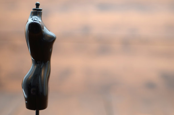 时尚设计理念，剪裁理念，黑色复古人体模型站在木制背景图片下载