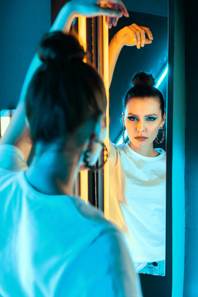 霓虹照明下的女孩肖像。画室里的漂亮女孩，带着彩光图片下载