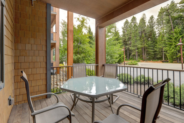 公寓风格的豪华度假居住公寓大楼阳台与松树景观和桌子与四椅子。图片下载