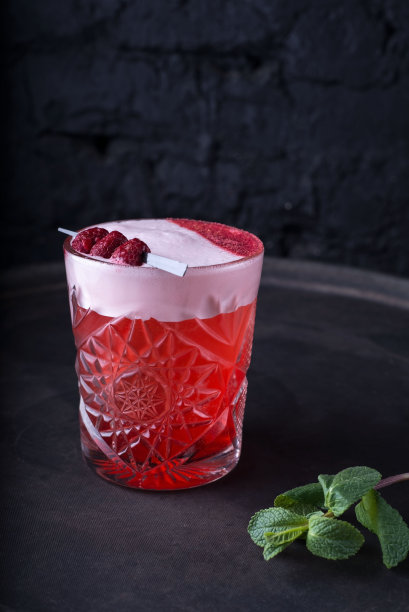 为派对准备的红色鸡尾酒的宣传照片。带有绿色的薄荷小枝和装饰性的覆盆子。在黑暗的背景上。以乡村风格。酒精图片下载