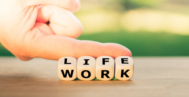 生活与工作。手转动骰子和改变单词“工作”到“生活”。图片下载